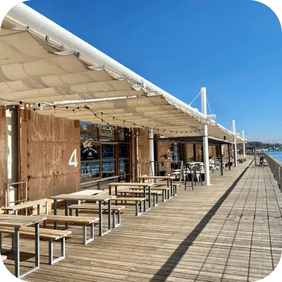 写真:海沿いのテラス席にテーブルがたくさん並んでいます